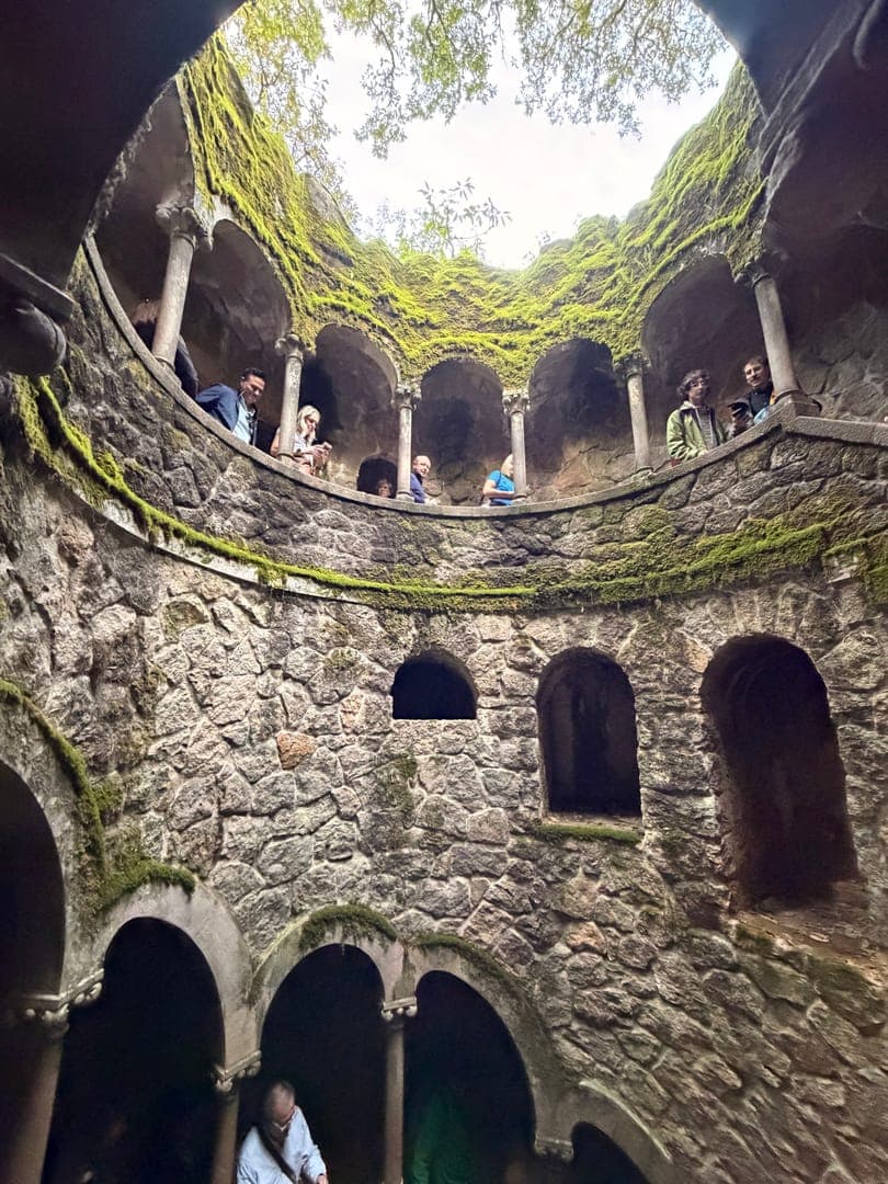Step into the enchanting depths of the Initiation Well at Quinta da Regaleira, where history and mystery intertwine. This incredible inverted tower, adorned with lush moss, draws visitors into its spiraling embrace, offering a unique perspective from its various levels. The intricate stonework and arched pathways create a captivating atmosphere, inviting exploration and wonder.